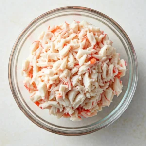 Dice 8 ounces of imitation crab meat and put it in a bowl. Combine it with 2 tablespoons of Kewpie Japanese mayonnaise, then set it aside.