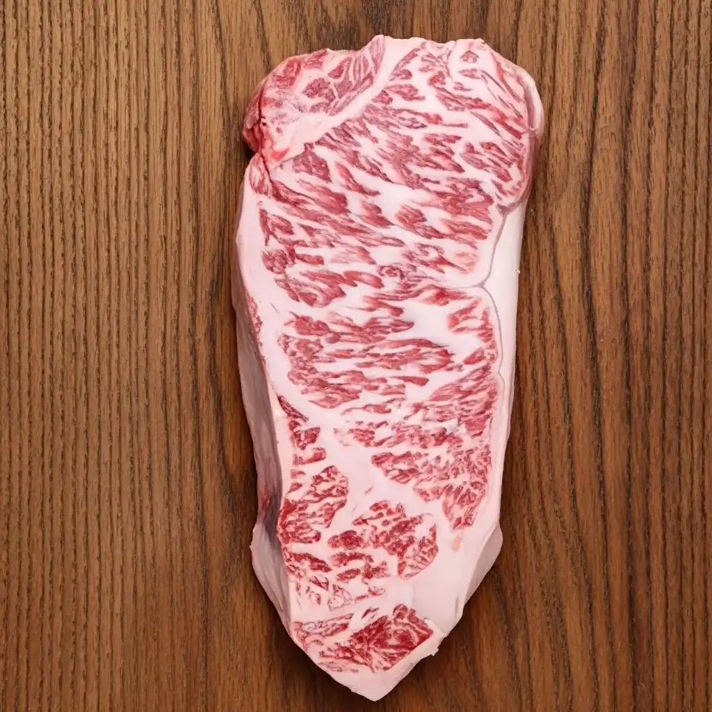 Fresh uncooked Kobe beef steak with rich marbling on a wooden board.