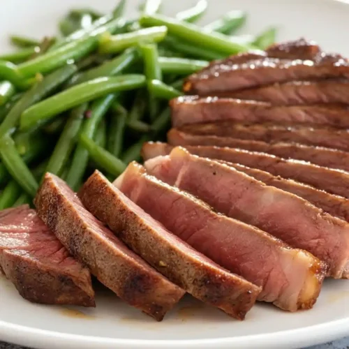 Sliced Kobe beef steak with green beans on a white plate – Kobe steak recipe side dishes