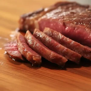 Close-up of sliced Kobe steak on wooden cutting board, juicy and medium rare – Kobe steak recipe