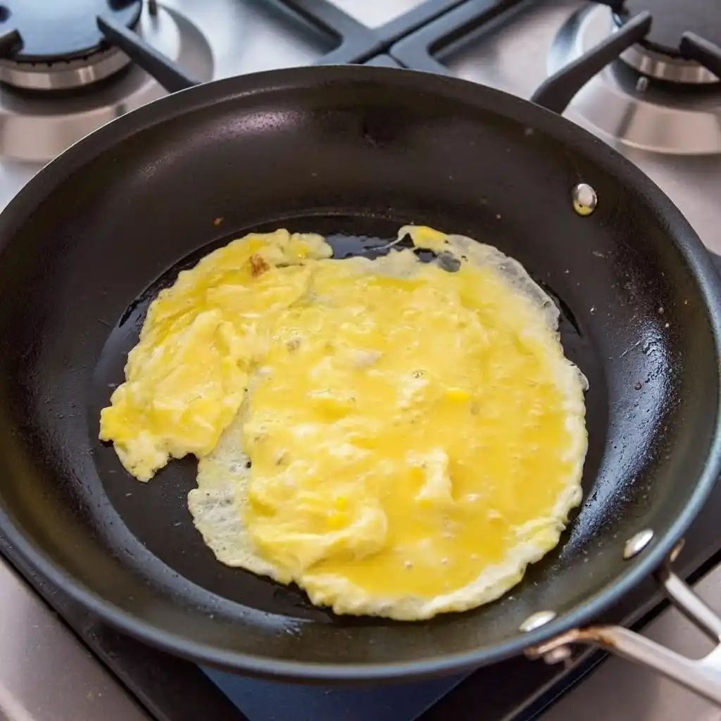 Scrambled eggs cooking in pan for shrimp fried rice recipe