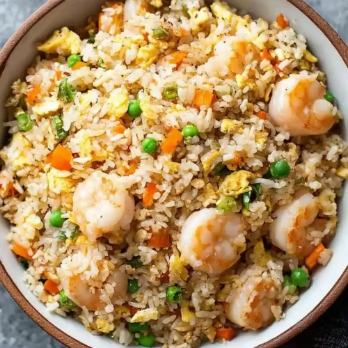 Authentic shrimp fried rice with peas, carrots, and eggs served in a bowl