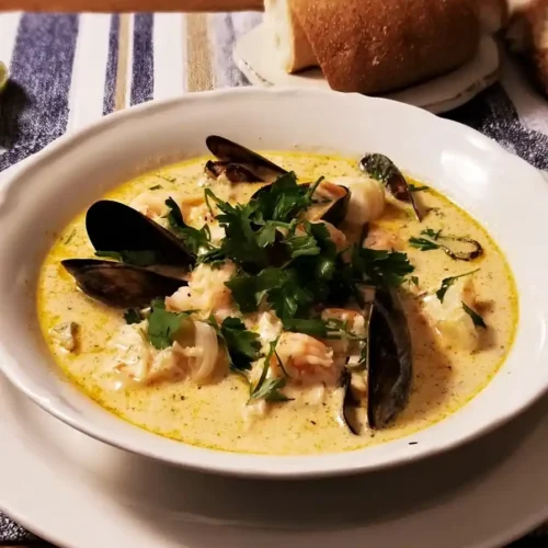 Seafood Chowder Bisque Fusion served with shrimp, mussels, and herbs