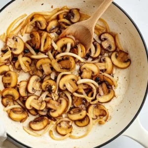 Mushrooms and onions sautéing in a pot with butter