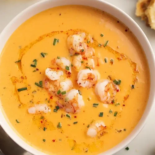 Cajun Shrimp Bisque in white bowl topped with shrimp and chives