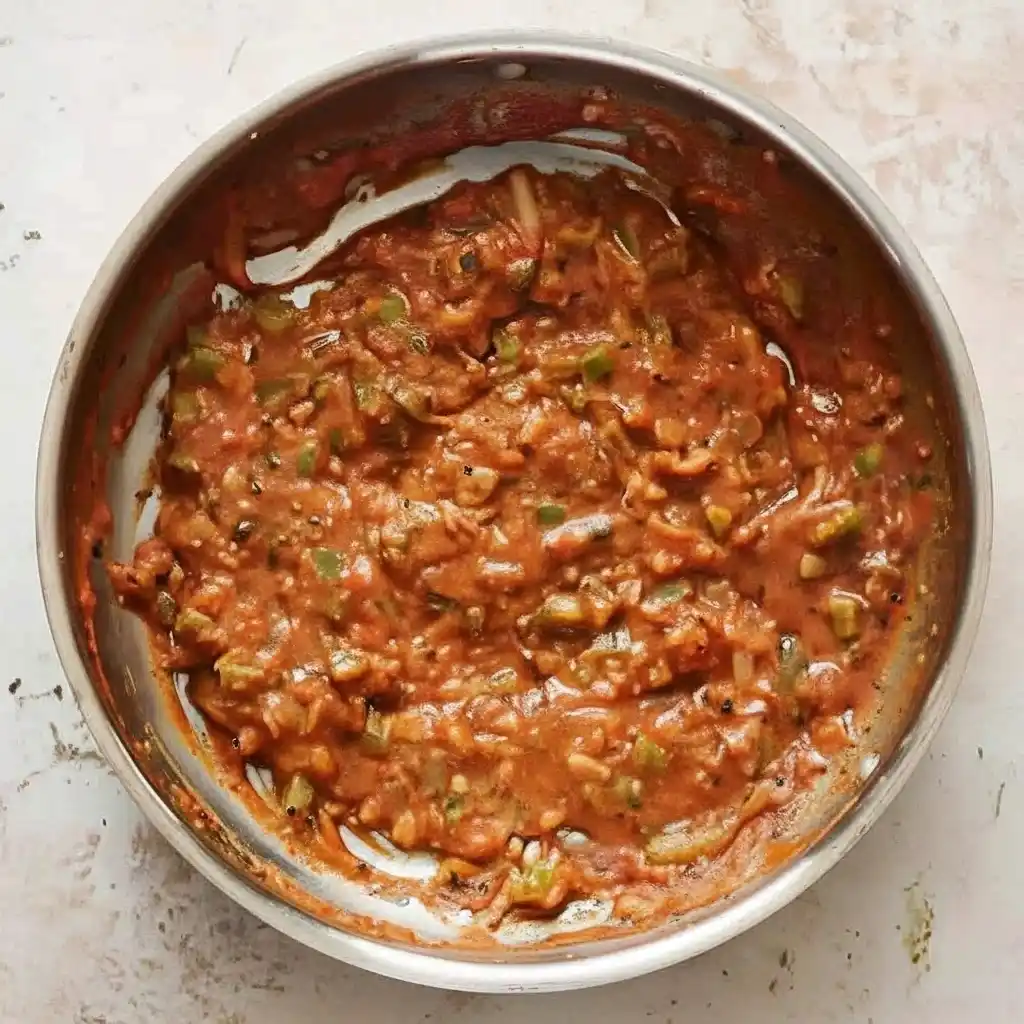 Tomato paste and flour cooking with sautéed vegetables in a pan for shrimp bisque recipe