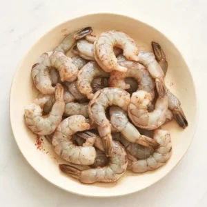 Raw shrimp cleaned and peeled on a plate for classic shrimp bisque recipe