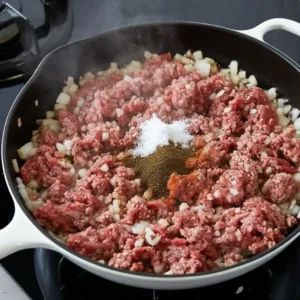 browning ground beef with onions in skillet