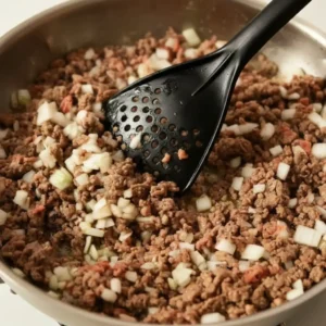 Ground beef and onions cooking in skillet