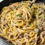 creamy one-pot garlic butter beef pasta in skillet topped with parsley