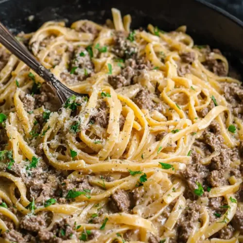 creamy one-pot garlic butter beef pasta in skillet topped with parsley
