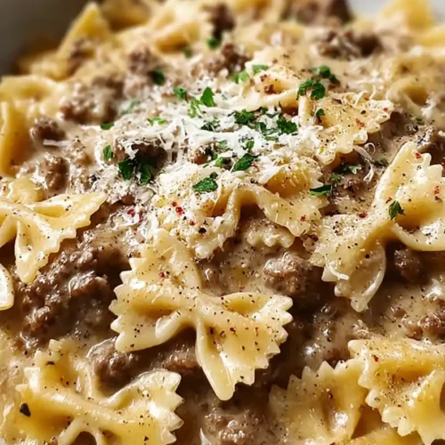 Creamy Parmesan Garlic Beef Bowtie Pasta served in a white bowl topped with Parmesan and parsley