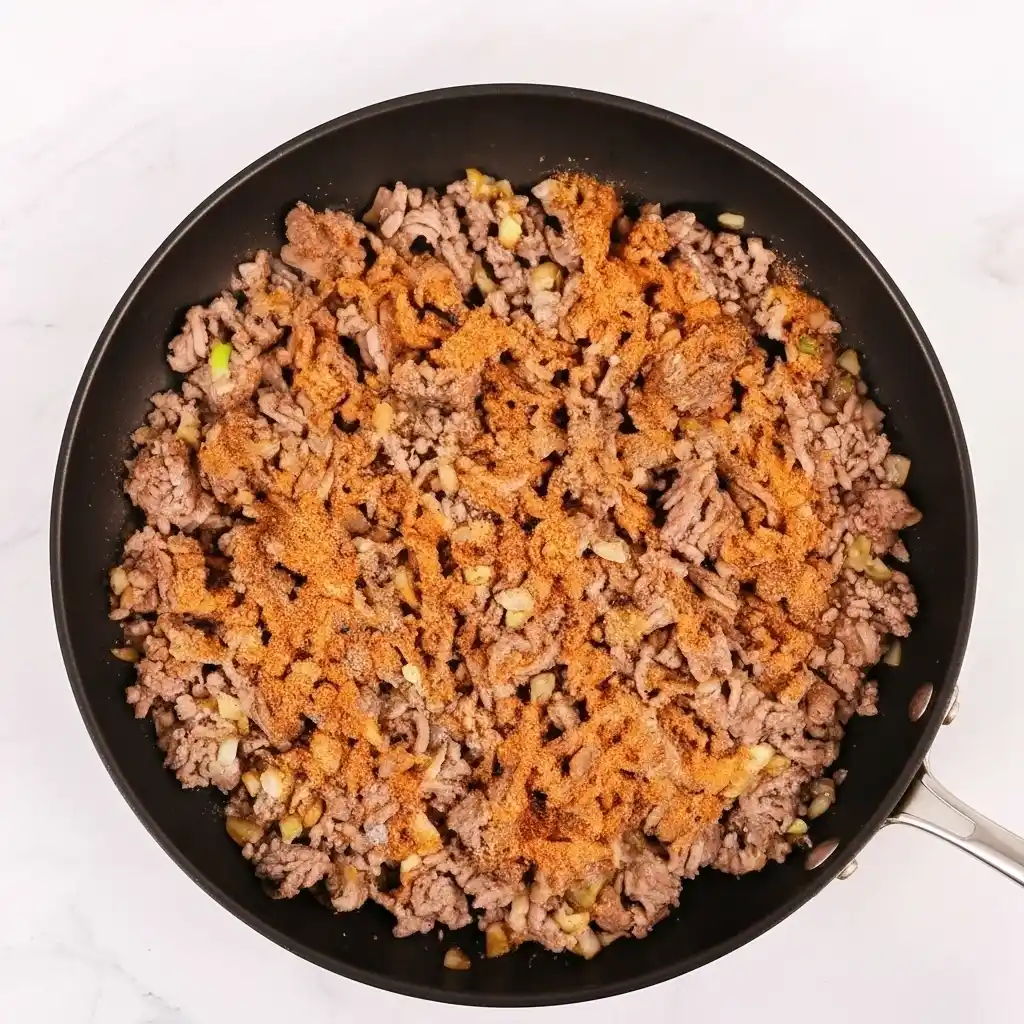 cooking ground beef with taco seasoning for enchiladas