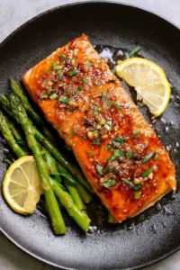 Plated salmon with asparagus and lemon wedges