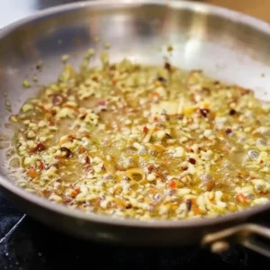 Garlic and chili flakes sizzling in olive oil and butter in a pan for shrimp scampi