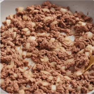 browning ground beef with onions in skillet