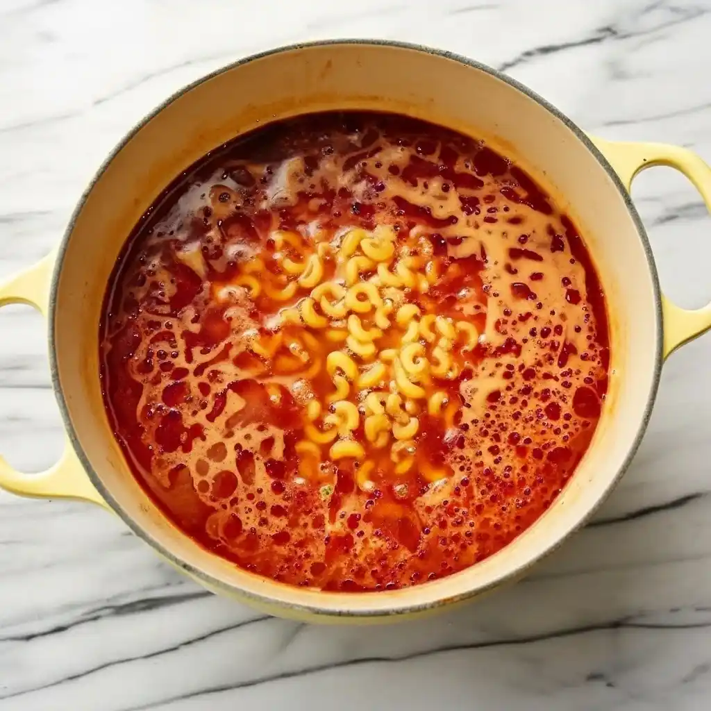 Ground beef and macaroni simmering in a tomato-based sauce for an easy homemade hamburger helper dinner.
