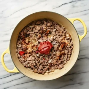 Homemade hamburger helper simmering in pot with pasta and beef