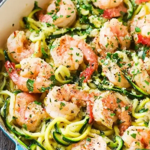 Healthy Lemon Shrimp Scampi with Zoodles in a blue pan with lemon garnish