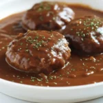 Salisbury Steak with Brown Gravy served in skillet topped with parsley