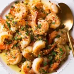 Spicy Shrimp Scampi with Chili Flakes on a white plate topped with garlic and parsley