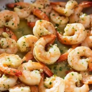 Shrimp cooking in buttery garlic chili sauce in a skillet