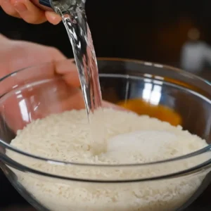 Rinsing sushi rice for Sticky Miso Salmon Bowl