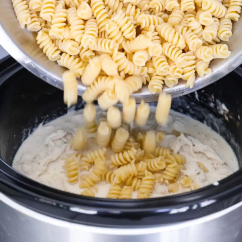 adding pasta to crock pot garlic parmesan chicken