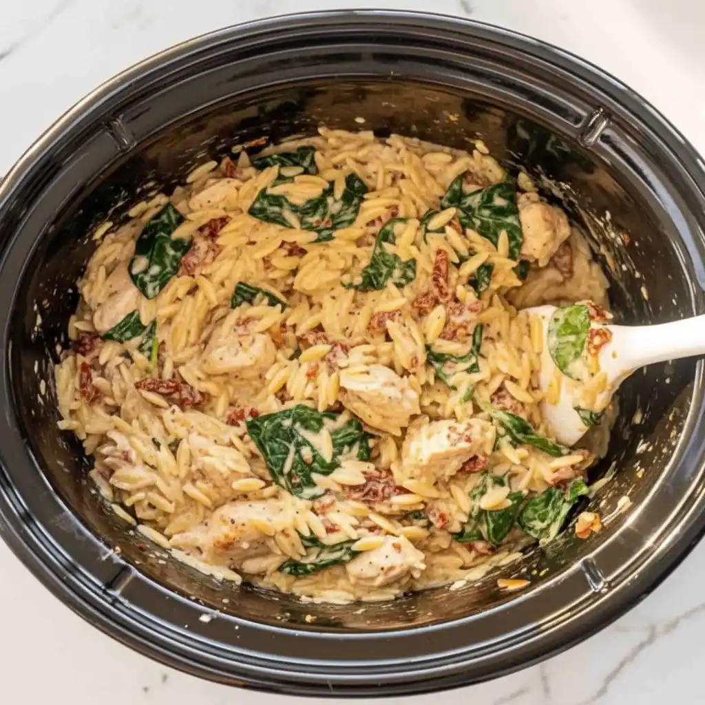 Creamy Tuscan chicken orzo with spinach and Parmesan in slow cooker
