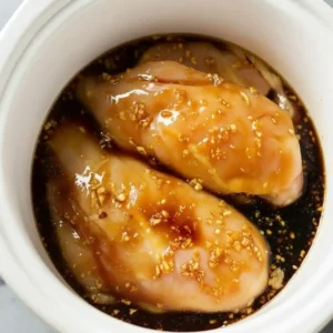 Dump and Go Teriyaki Chicken raw chicken thighs in teriyaki sauce inside slow cooker