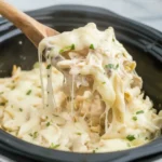 cheese pull from creamy crockpot chicken alfredo bake