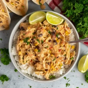 Fiesta Chicken Crock Pot served over rice with lime wedges and cilantro