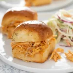 Two Buffalo Chicken Sliders served on a white plate with coleslaw — warm, cheesy, and flavorful.