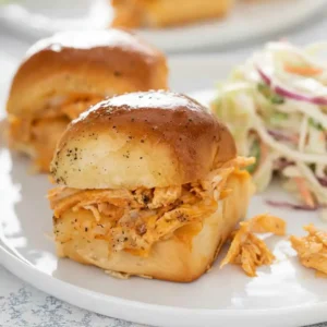 Two Buffalo Chicken Sliders served on a white plate with coleslaw — warm, cheesy, and flavorful.
