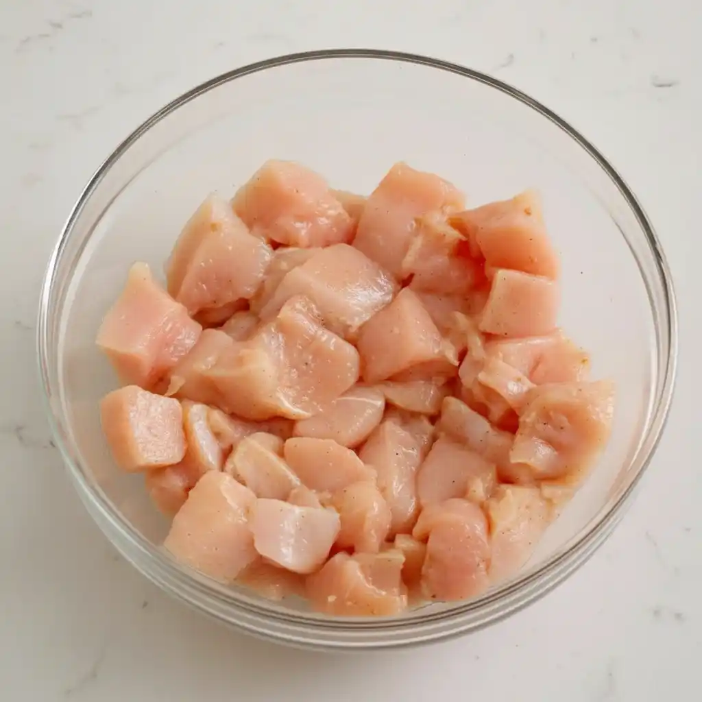 Marinated chicken pieces in glass bowl